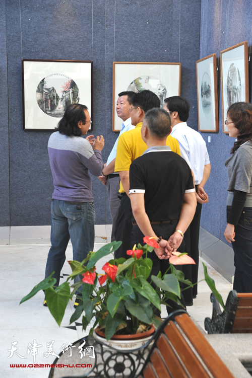 庞雨在2013画展上为来宾讲解