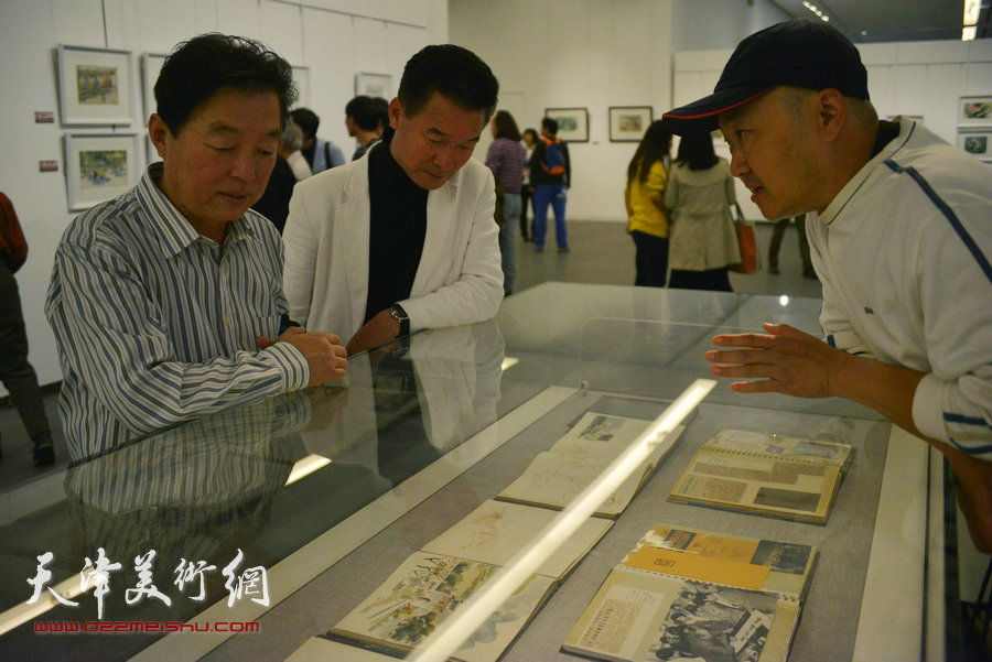 杨建国、陈之海、柴博森在观看画作。