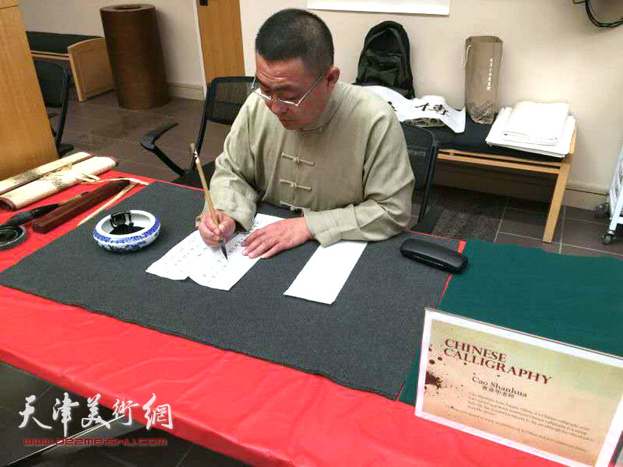 图为曹善华在盐湖城城市图书馆个人书法作品展演示小楷写法。