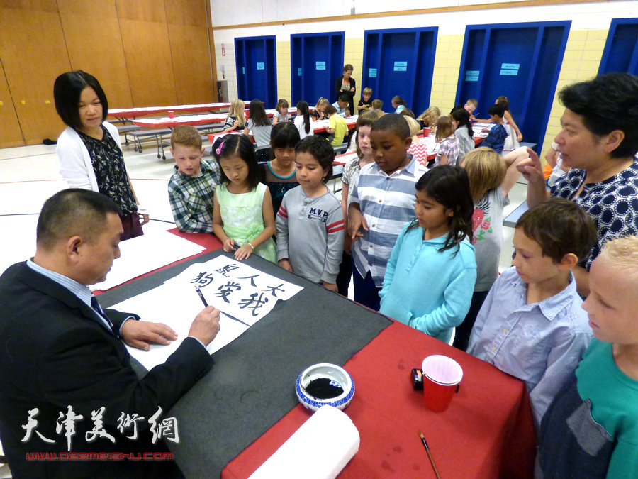 曹善华在徳波小学辅导演示书法。