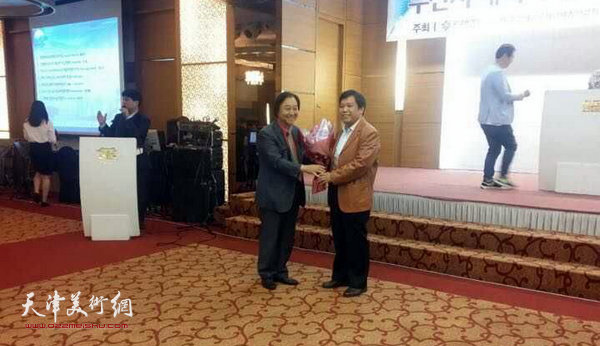 釜山艺术团体总联合会理事长宋泳明为李耀春献花祝贺。