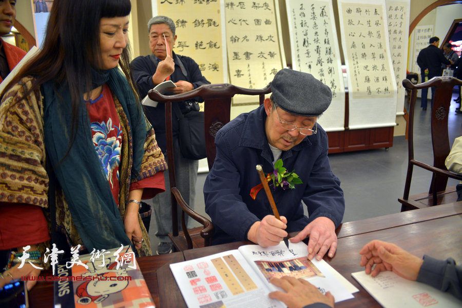 李泽润为观众签名《津门七叟诗联书画印大展作品集》。