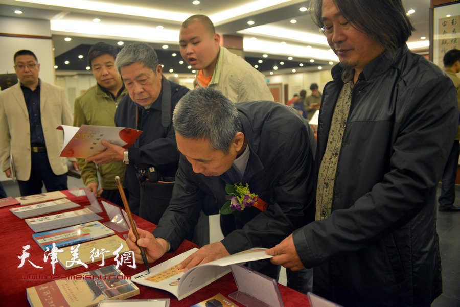 卢善启为观众签名《津门七叟诗联书画印大展作品集》。