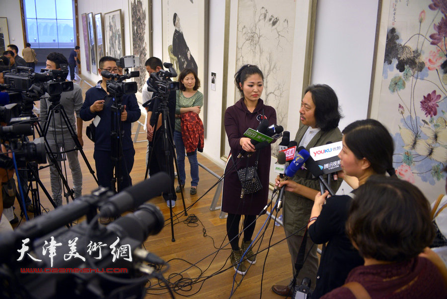 贾广健在画展现场接受媒体采访。