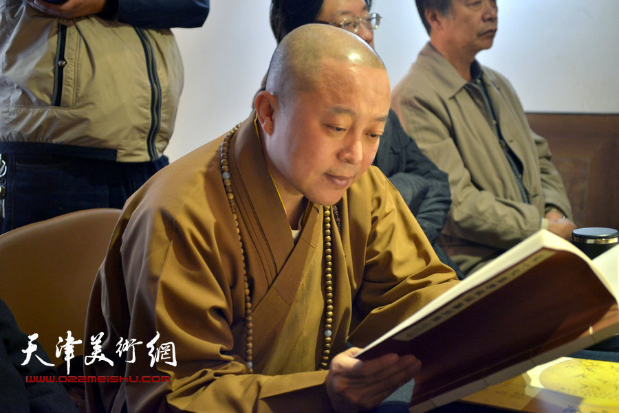 天津大悲禅院住持智如法师在首发式上阅读《弘一大师李叔同篆刻集》新编增补本。