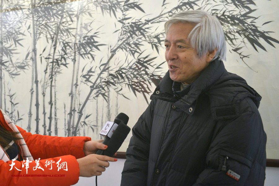 陆福林在画展现场接受媒体的采访