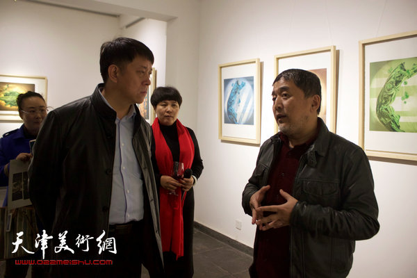 图为范敏与滨海新区区委宣传部副部长王东红在画展现场交谈。