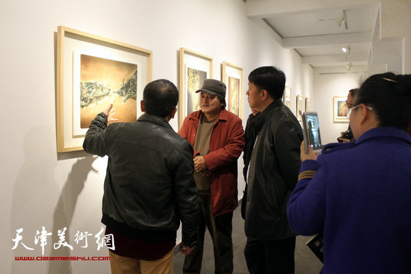 图为范敏在画展现场向王东红、李英杰等介绍展品。