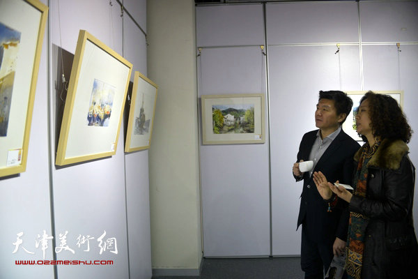 水彩画家陶香莲向鲍健介绍展出的作品。