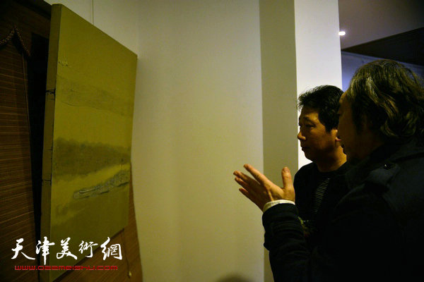 图为王小杰、李伟在观赏画作。