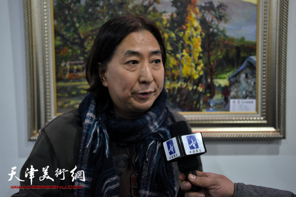 图为杨亦谦在画展现场接受媒体采访。