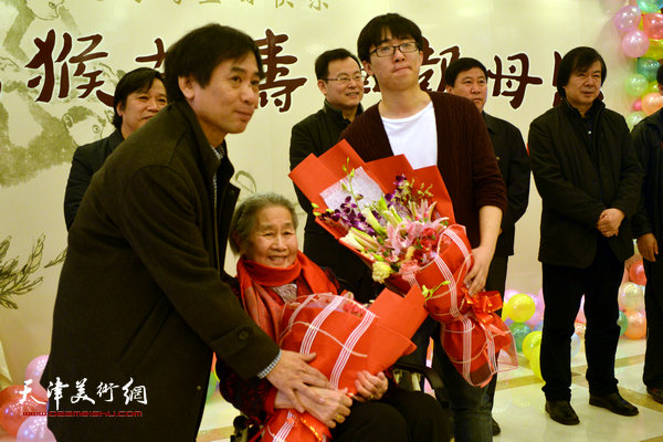 肖培金向89高龄的老母亲高连荣敬献鲜花。
