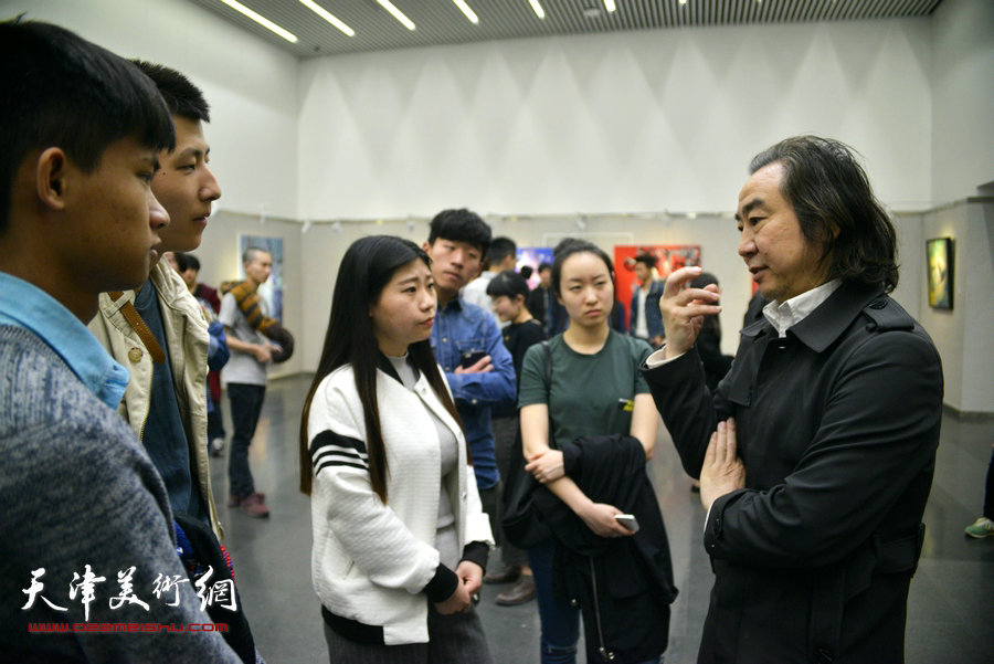 图为王小杰与同学们在画展现场交流。