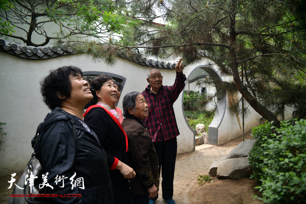 图为张锡武陪同天津画家在“牡丹园”观赏植物。