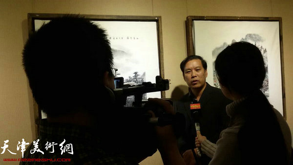 徐庆举在画展现场接受媒体采访。