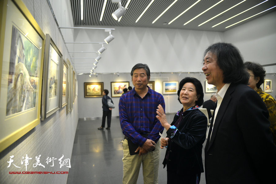曹秀荣、刘新华、胡万荣在观赏画作。