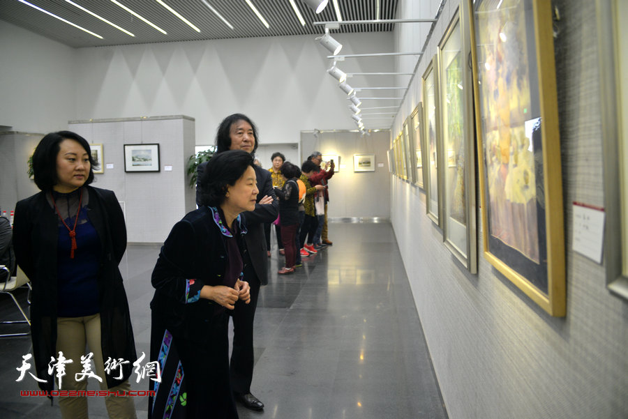 曹秀荣、刘新华、孙瑜在观赏画作。