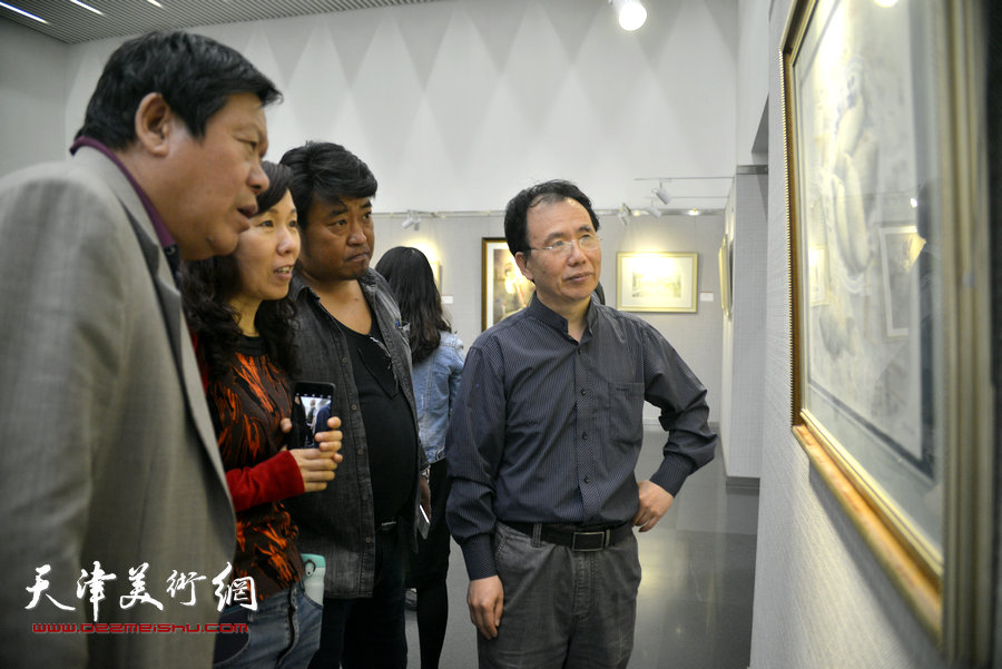 郭鸿春、庞恩昌与来宾在观赏画作。