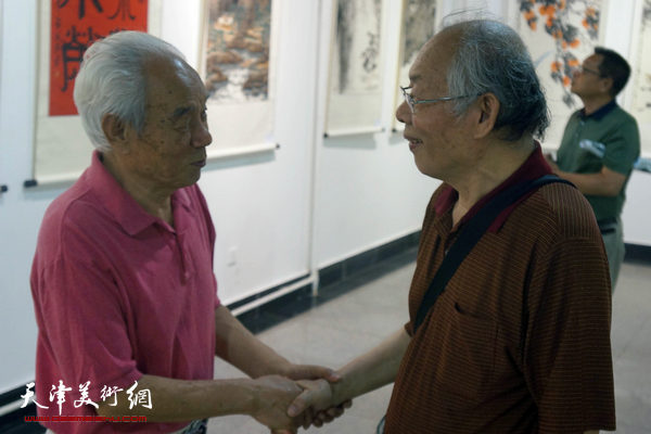 受邀前来的著名画家纪振民和蔡金顺相会在展厅