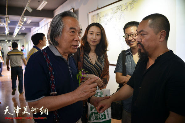 霍春阳与刘金凯在书画展现场交流。