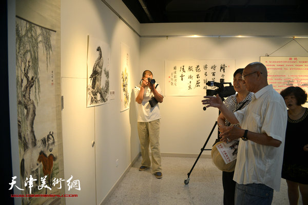 孙克维与书画爱好者在观赏展品。