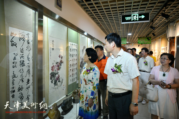 曹秀荣、李桂金、冯字锦在观赏画作。