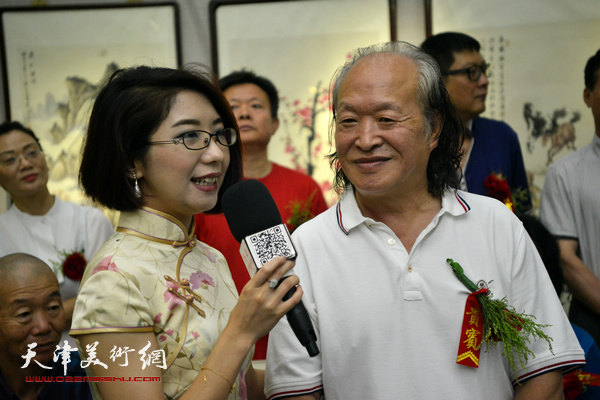 刘家栋接受画展开幕仪式主持人周婉莹现场提问。