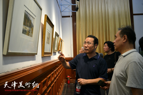 杨俊甫在观赏展出的作品。