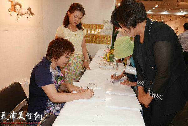 李澜在画展现场为观众签名。