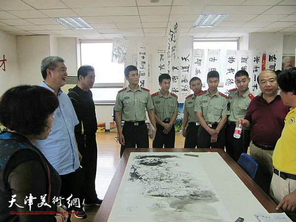书画家与部队官兵在活动现场交流。