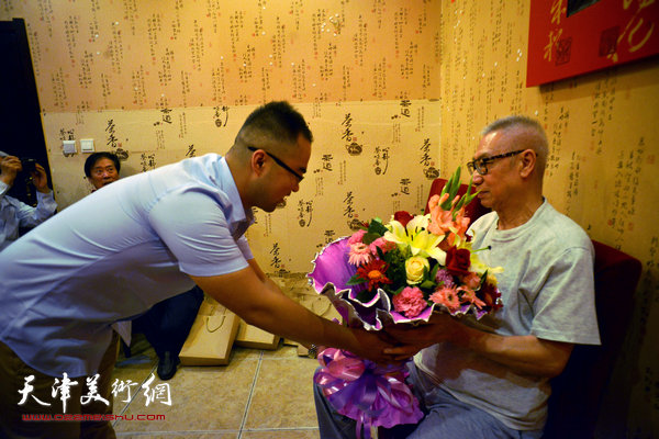 弟子王文哲为师傅刘洪麟献花。