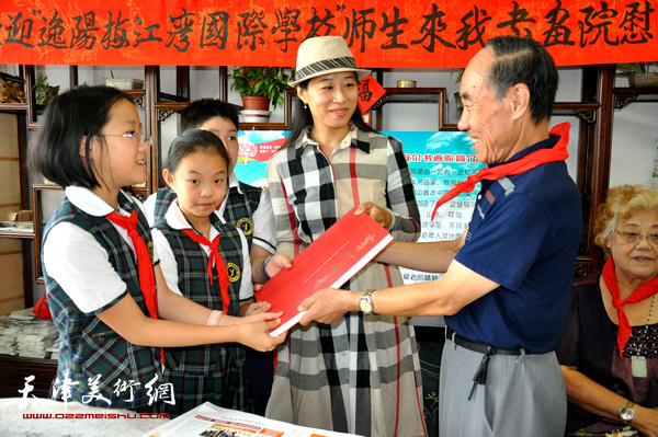 刘文学表书画院向学校赠送书画集。