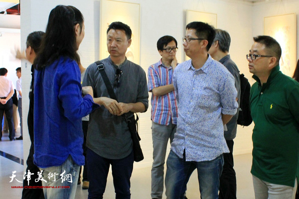 李旺与来宾在画展现场交流。