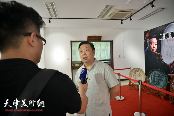 马魏华在展览现场接受媒体采访。