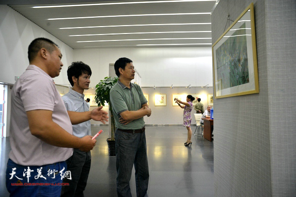 吴振江与西青美协主席李桂金等观赏作品。