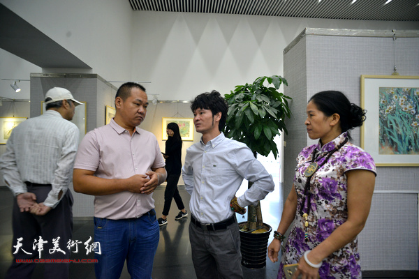 吴振江与来宾在画展现场交流。