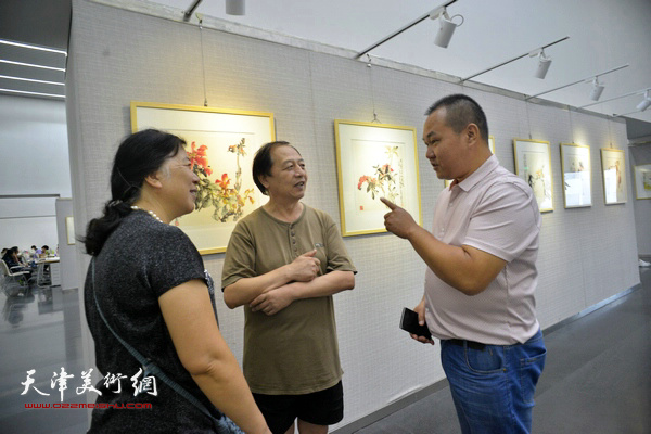 吴振江与来宾在画展现场交流。