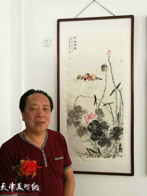 画家纪荣耀在画展现场。