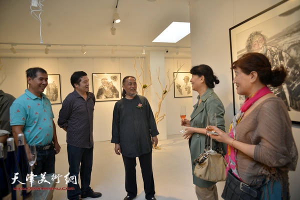 姚海峰与董克诚等来宾在画展现场交流。