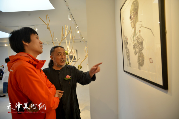 姚海峰与咸景洛在观赏作品。