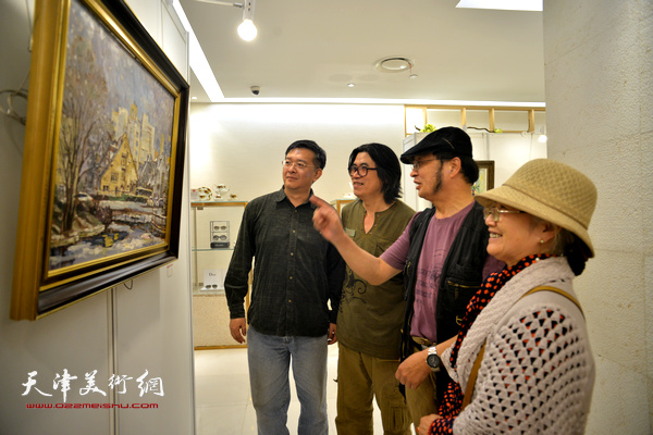 齐阳、吴薇、贾建东、石瑞福在观赏展出的风景油画作品。