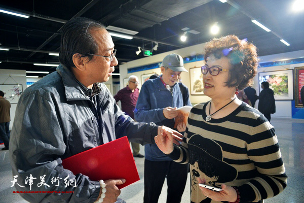 郑爱国与张琪在“秋之韵”书画展上交流。