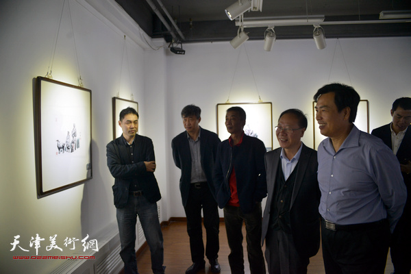 李耀进、邓国源、庞黎明、高山在观赏展出的作品。