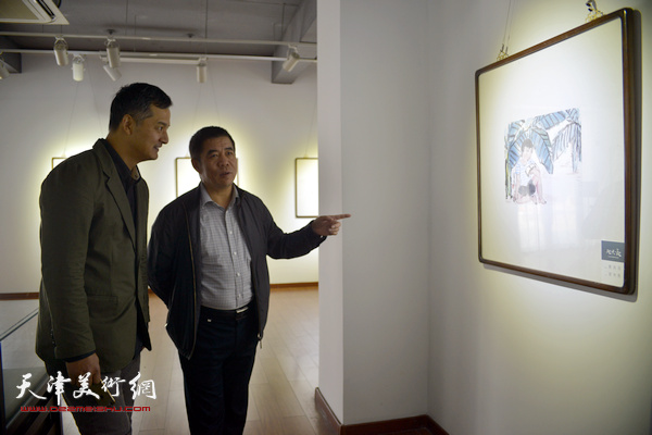 杨维民、窦良羽在观赏展出的作品。