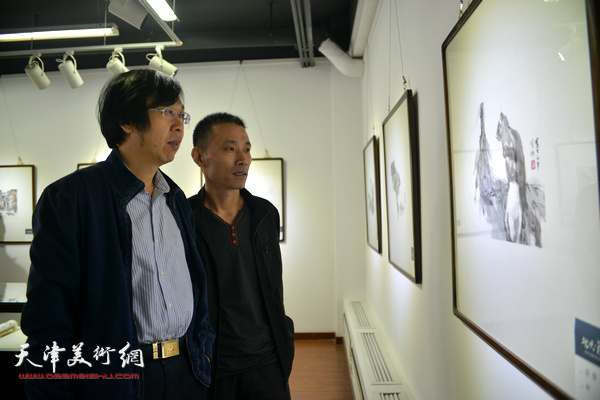 路洪明、段为民在观赏展出的作品。