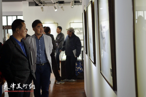 王涛在观赏展出的作品。