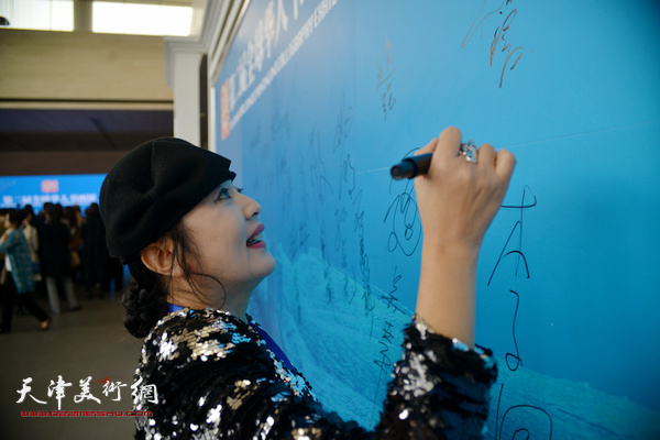 海外华人画家在画展现场签到。