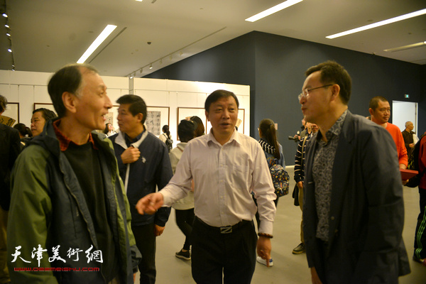 龙建忠、张桂元、韩昌力在画展现场交流。