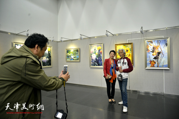 张明德与来宾在画展现场。