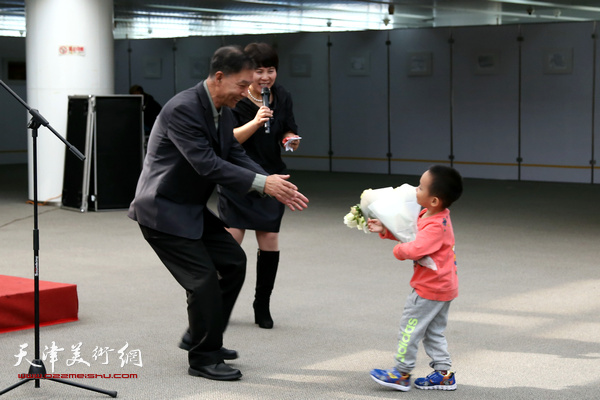 李建平老师的孙子代表全家人向爷爷开画展献花。